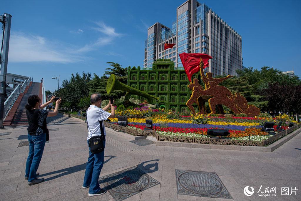 6月22日，市民在建党百年主题花坛前拍照留念。人民网记者翁奇羽 摄